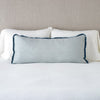 Paloma Throw Pillow | Mineral | 16x36 charmeuse pllow wth silk velvet trim against white sleeping pillows and sheets — straight on with neutral background.