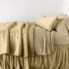 Paloma Blanket | Honeycomb | throw blanket rumpled on a charmeuse monochromatic bed - side view.