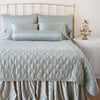 Paloma Pillowcase (Single) | Mineral | Paloma sleeping pillows on a monochromatic, all-charmeuse bed - mineral, end of bed view.