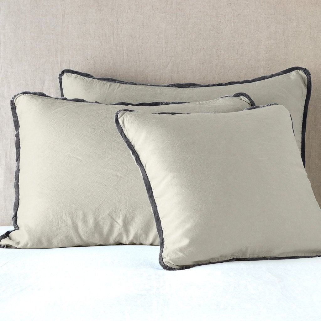 Paloma shams leaning upright on white sheeting against a neutral headboard - fog.