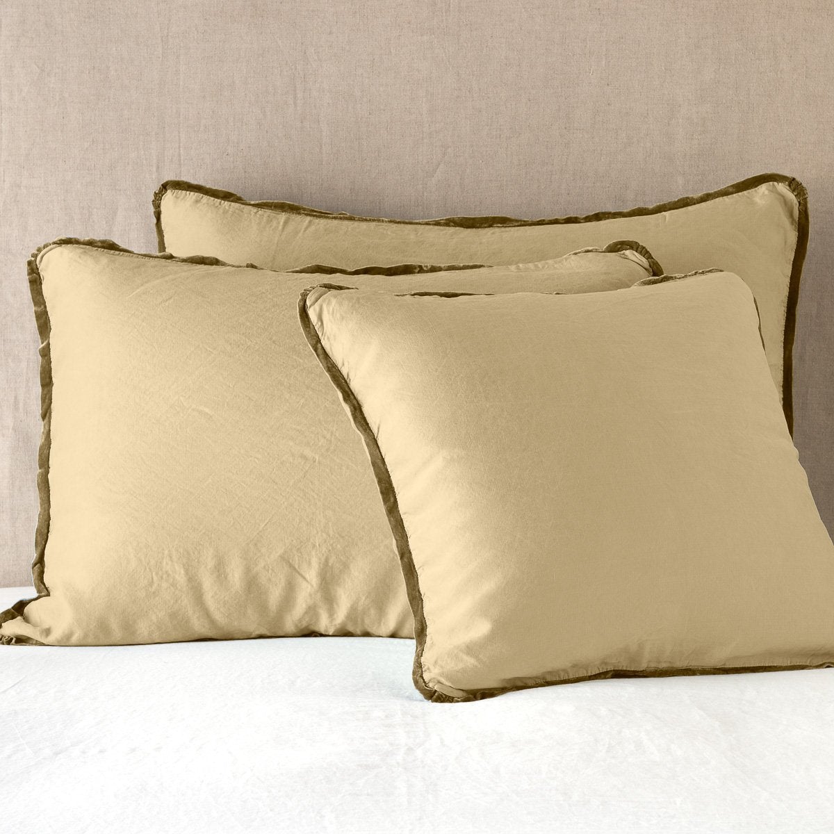 Paloma Sham | Honeycomb | shams leaning upright on white sheeting against a neutral headboard.