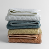 Silk Velvet Quilted Baby Blanket | stack of 4 quilted silk velvet baby blankets in white, cloud, parchment and rouge against a white background.