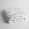 Silk Velvet Quilted Baby Blanket | White | a folded quilted silk velvet baby blanket shown from overhead to showcase quilting  pattern and texture.
