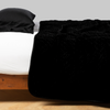 Silk Velvet Quilted Coverlet | Corvino | coverlet neatly arranged on white sheeting with matching sleeping pillow - side view.