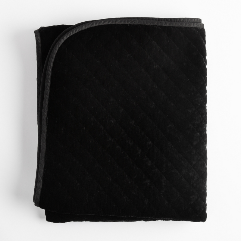 Silk Velvet Quilted Blanket | Corvino | folded blanket shows satin piping detail - overhead on white background.