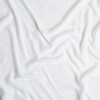 Loulah Blanket | White | A close up of silk velvet fabric in classic white.