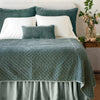 Silk Velvet Quilted Twin Coverlet | Eucalyptus | coverlet and matching shams on a neatly made, white bed - end of bed view.