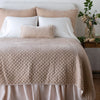 Silk Velvet Quilted Twin Coverlet | Pearl | coverlet and matching shams on a neatly made, white bed - end of bed view.