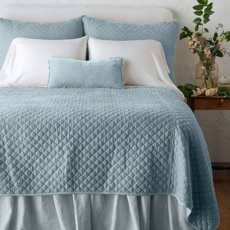 Silk Velvet Quilted Sham | Cloud | shams with matching coverlet on a neatly-made, bed with white sheeting - end of bed view.