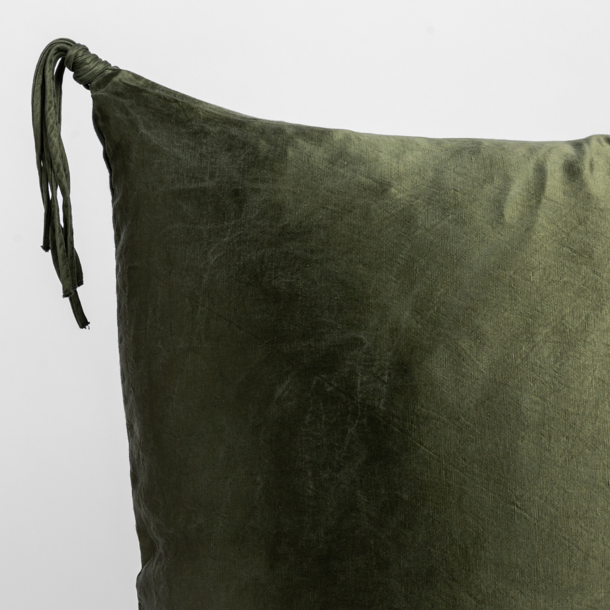 Taline Sham | Juniper | close up of a charmeuse pillow corner and tassel against a white background.