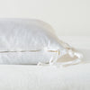 Taline Throw Pillow | White | Close-up side vew featuring brass zipper with charmeuse pull and linen back.