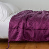 Taline Blanket | Fig | blanket draped over a white bed - side view.