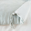 Taline Blanket | Cloud | Close up of blanket, with a corner turned back to showcase the midweight linen back and corner tassel - overhead view.