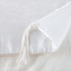 Taline Blanket | White | Close up of blanket, with a corner turned back to showcase the midweight linen back and corner tassel - overhead view.