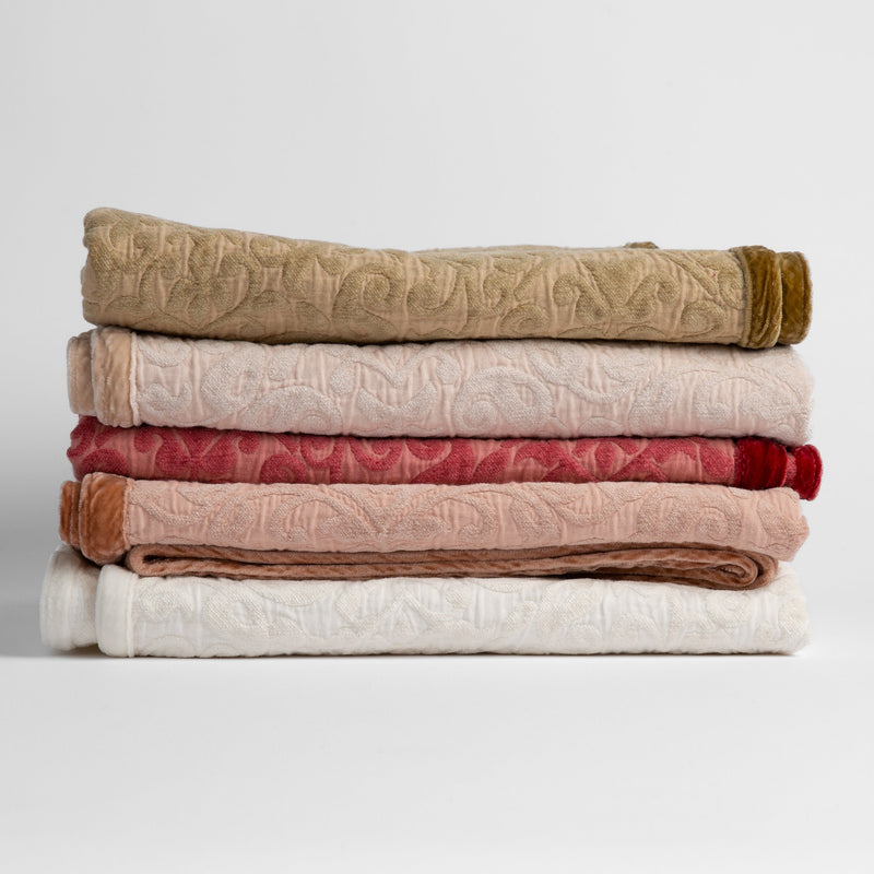 Vienna Baby Blanket | stack of cotton chenille baby blankets in honeycomb, pearl, poppy, rouge and winter white - silk velvet edges alternating sides of the stack. 