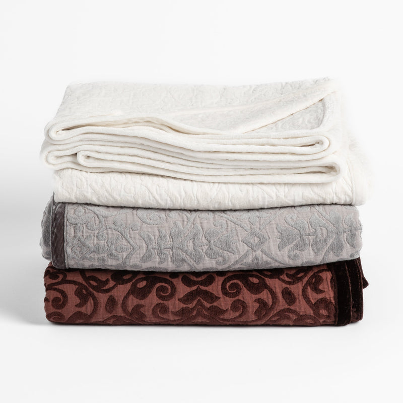 Vienna Blanket | three cotton jacquard chenile blankets in winter white, moonlight and mahogany folded and stacked neatly on a plain white background. 