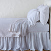 Vienna Coverlet | White | Cotton chenille jacquard coverlet and matching sham over white sheeting - side view.