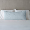 Vienna Throw Pillow | Cloud | 16x36 pillow leaning upright against white sleeping pillows on a neutral headboard.