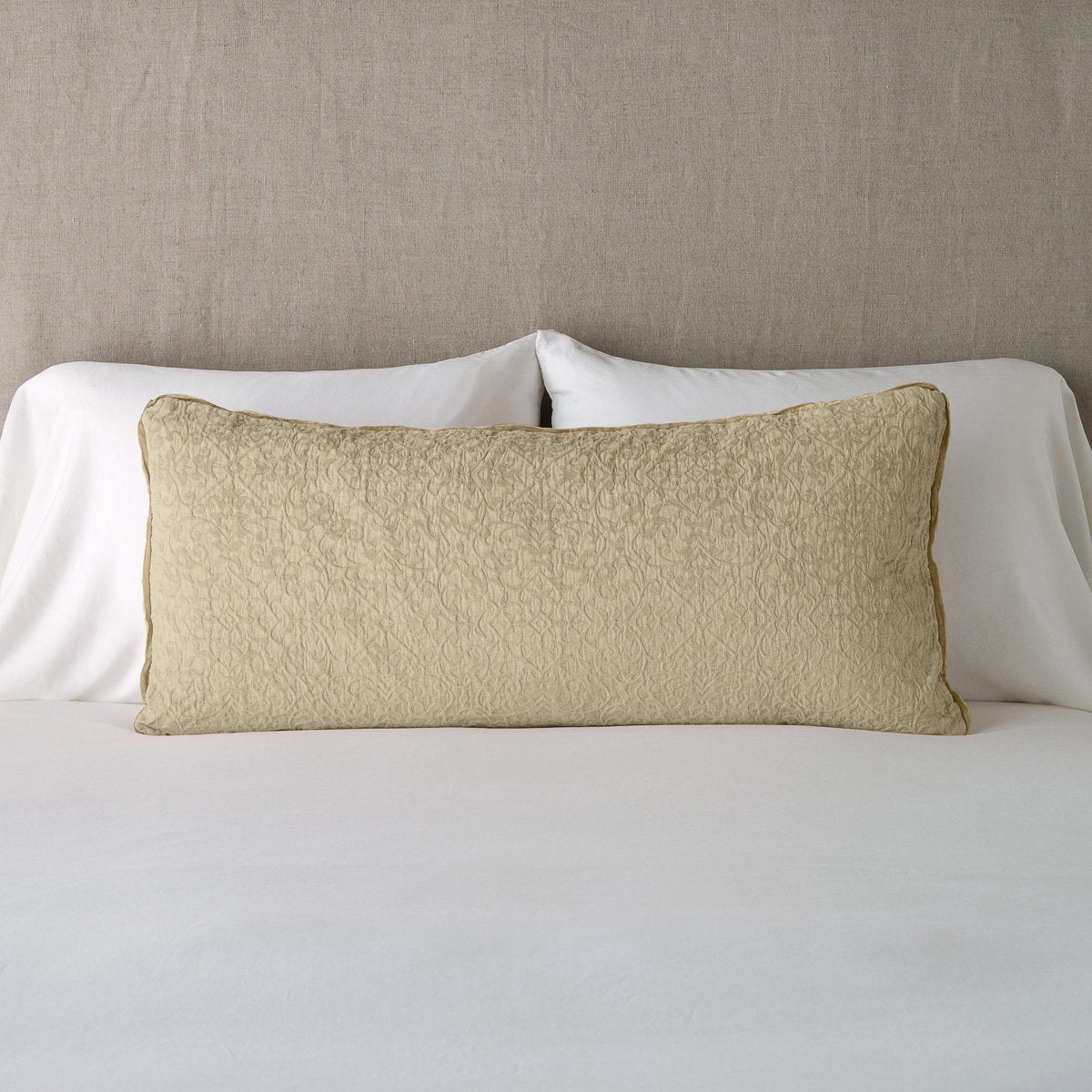 Vienna Throw Pillow | Honeycomb | 16x36 pillow leaning upright against white sleeping pillows on a neutral headboard.