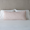 Vienna Throw Pillow | Pearl | Vienna 16x36 pillow leaning upright against white sleeping pillows on a neutral headboard - pearl.