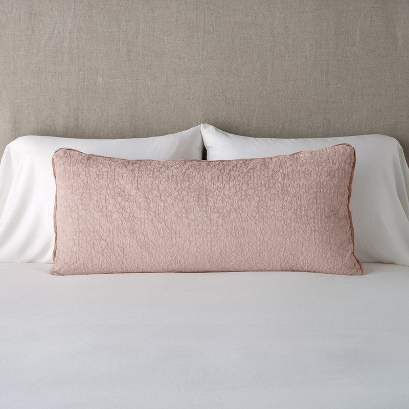Vienna Throw Pillow | Rouge | 16x36 pillow leaning upright against white sleeping pillows on a neutral headboard.