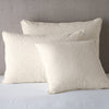 Vienna Sham | Parchment | Cotton chenille jacquard shams leaning upright against a neutral headboard.