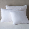 Vienna Sham | White | Cotton chenille jacquard shams leaning upright against a neutral headboard.